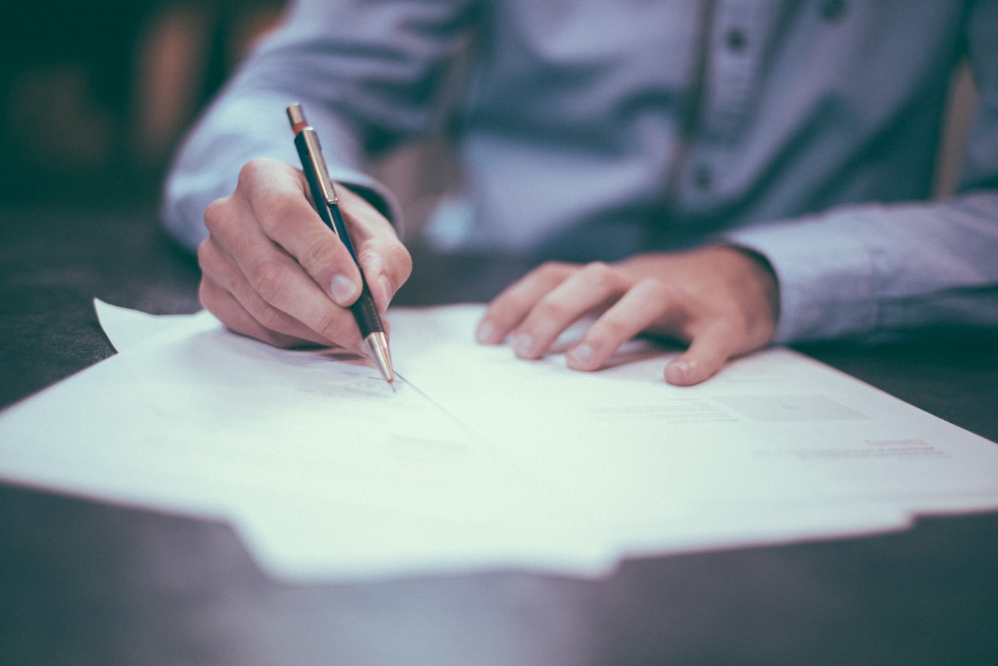 Client signing a retainer agreement at a law office desk